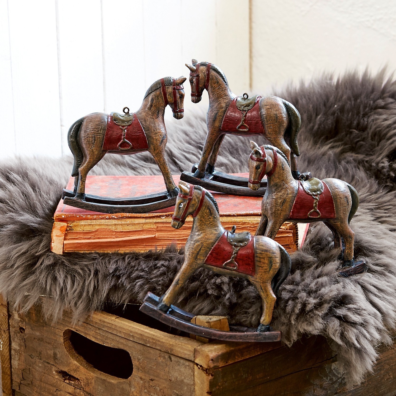 Sierpaard set van 4 Cory Set van vier bruine houten hobbelpaarden met rode zadels als rustieke woondecoratie.