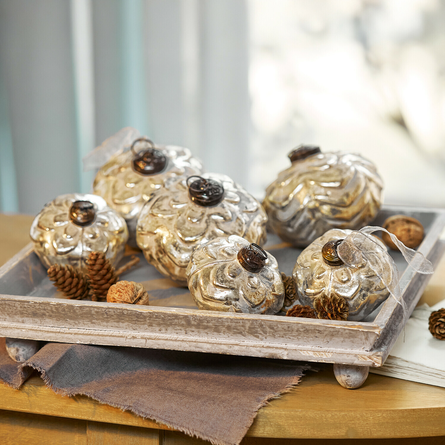 Kerstballen set van 6 Xilianne Decoratieve zilverkleurige glazen bloemvormige ornamenten op een houten dienblad op tafel