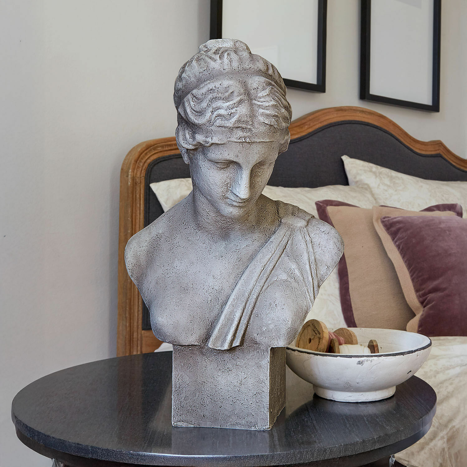 Buste Castolio Grijs stenen buste op zwarte tafel in elegante kamer met sierkussens