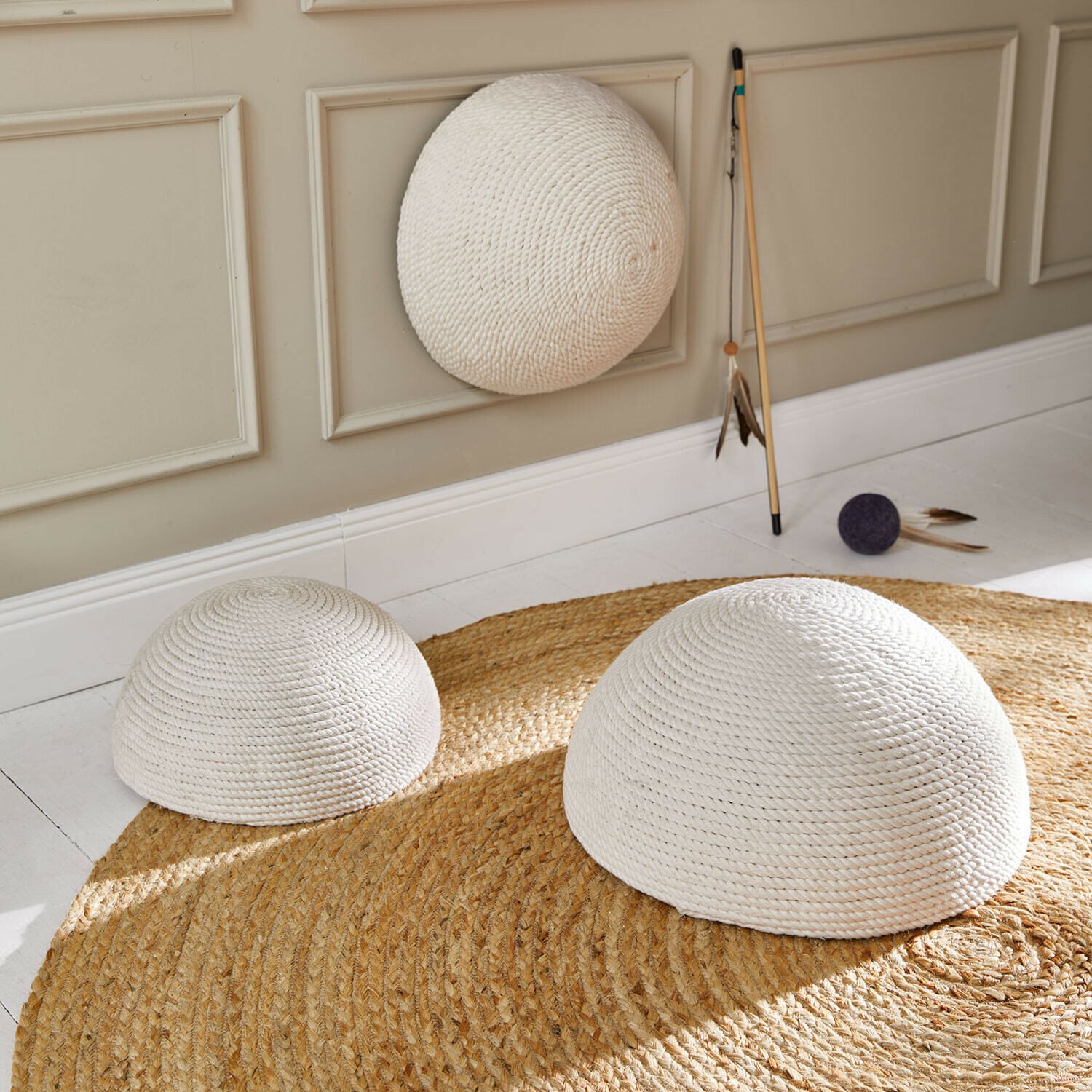 Krabornament set van 3 Hallira Drie witte halve bollen van gevlochten touw op een ronde jute vloerkleed in een lichte kamer