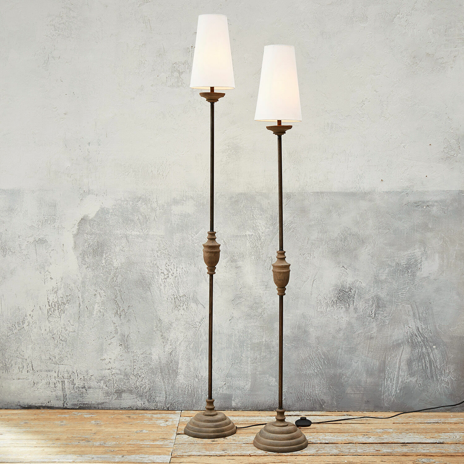 Staande lamp set van 2 Abigail Twee staande lampen van metaal en hout met witte lampenkappen op een lichte houten vloer