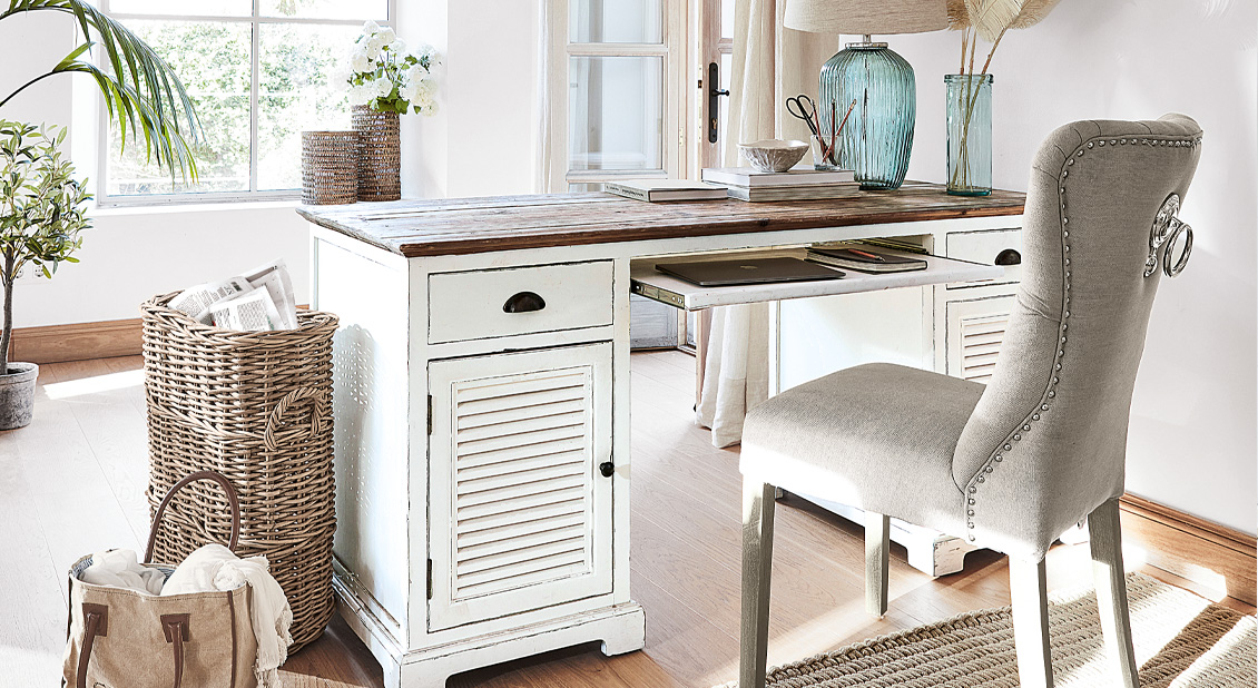 Witte houten shabby chic bureau met lades en grijze gestoffeerde stoel in lichte kamer
