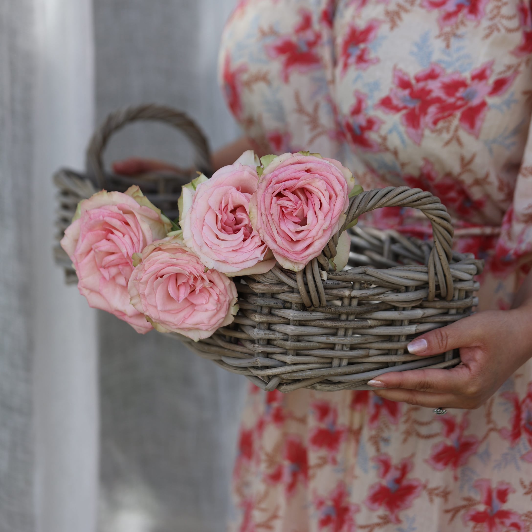 Grijze rieten dienblad met handvatten en roze rozen, rustieke decoratie