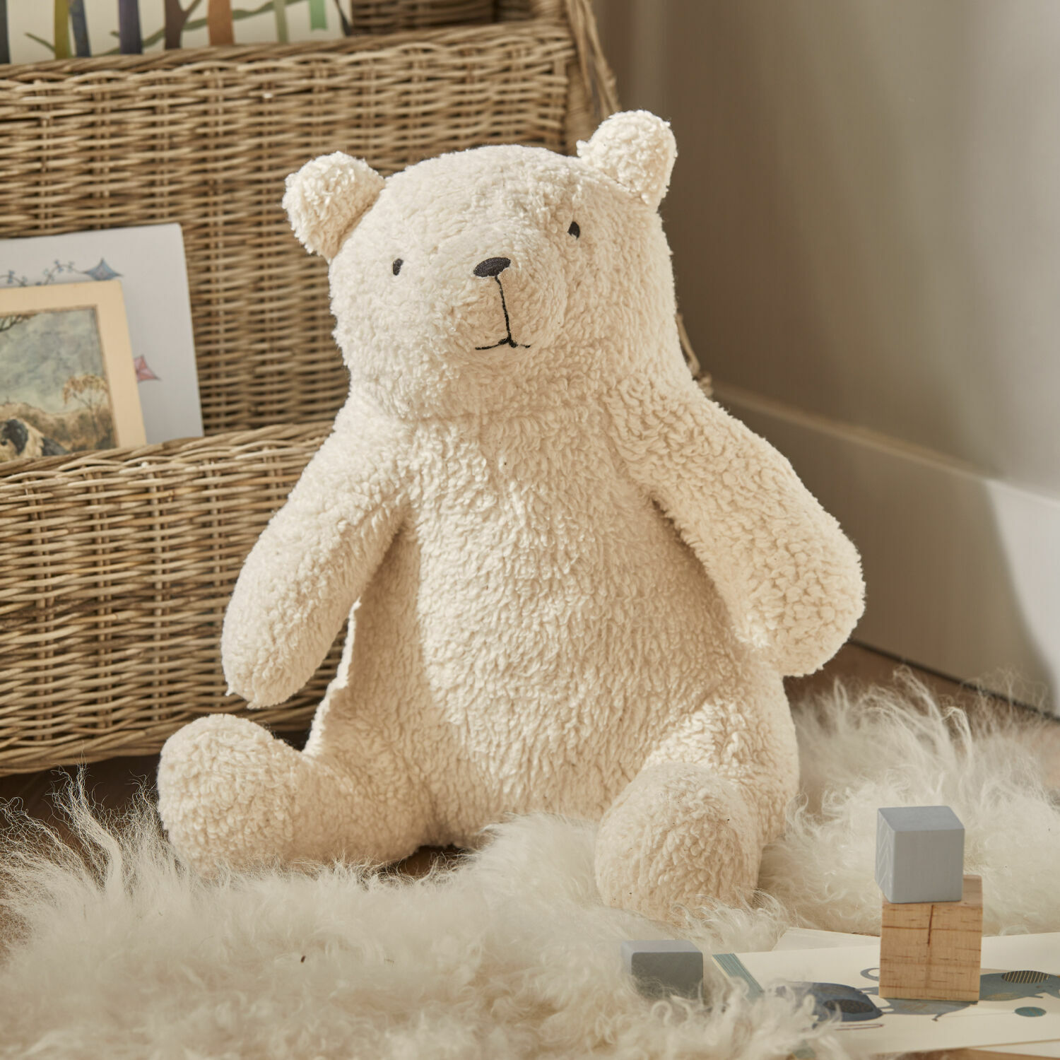 Knuffeldier Hugo Zachte crème pluche beer op tapijt van natuurlijke materialen, kinderkamerdecoratie