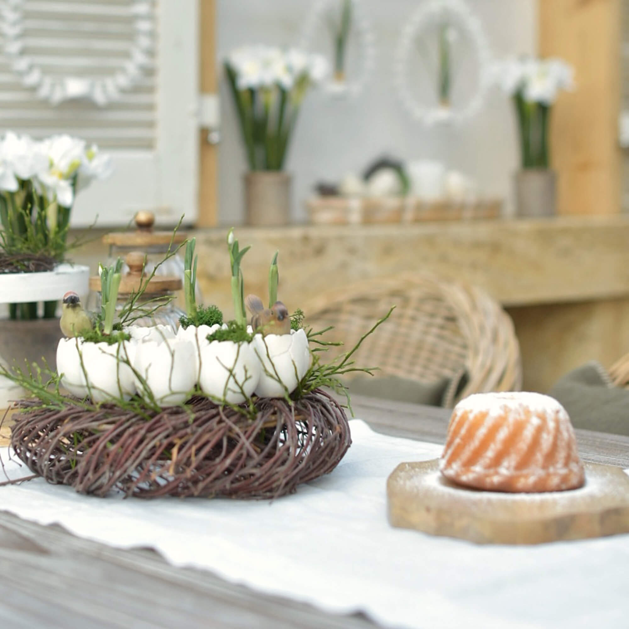 Natuurlijke paasdecoratie met witte eierschalen en groene planten op een wilgenkrans