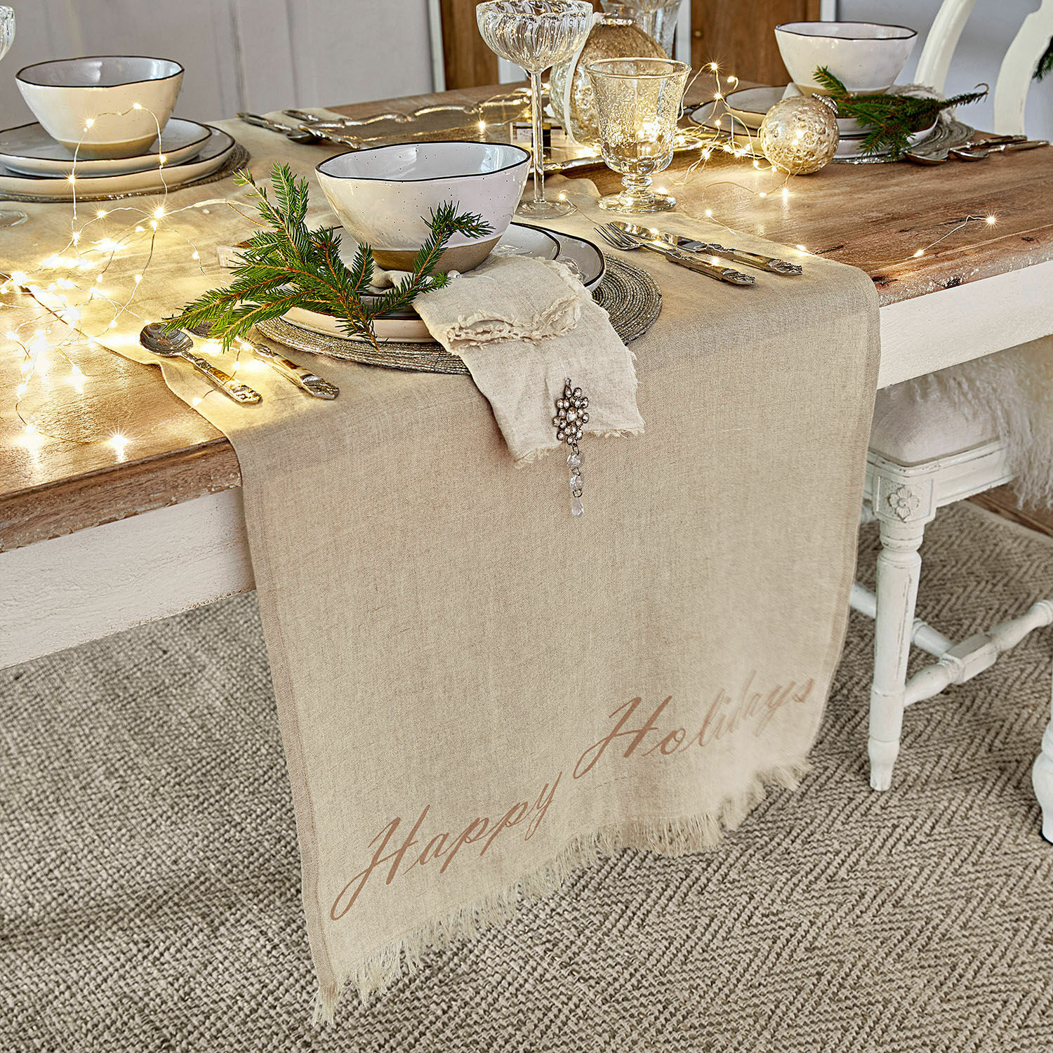 Beige linnen tafelloper op houten tafel met feestelijke decoratie en servies