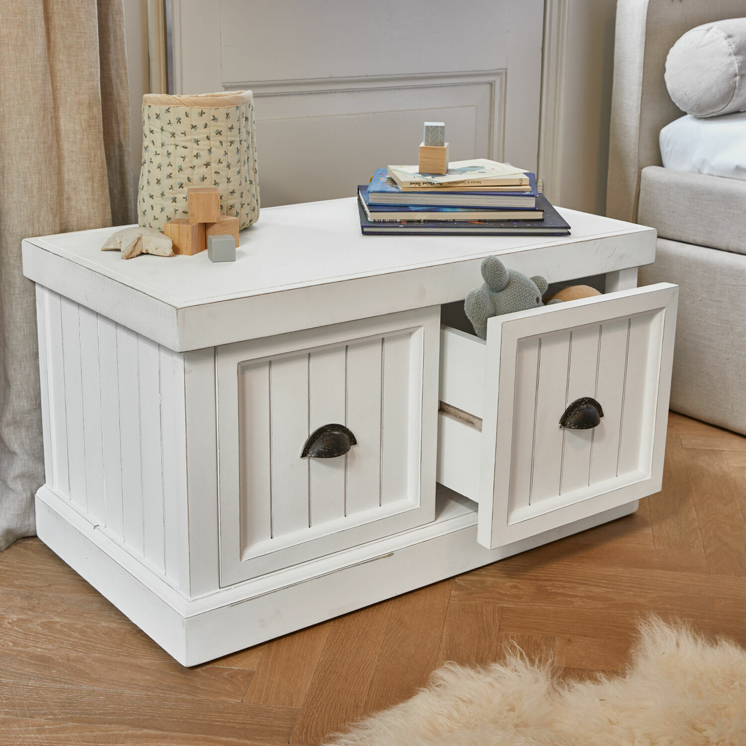 Witte houten salontafel met lades en metalen handgrepen op lichte houten vloer.