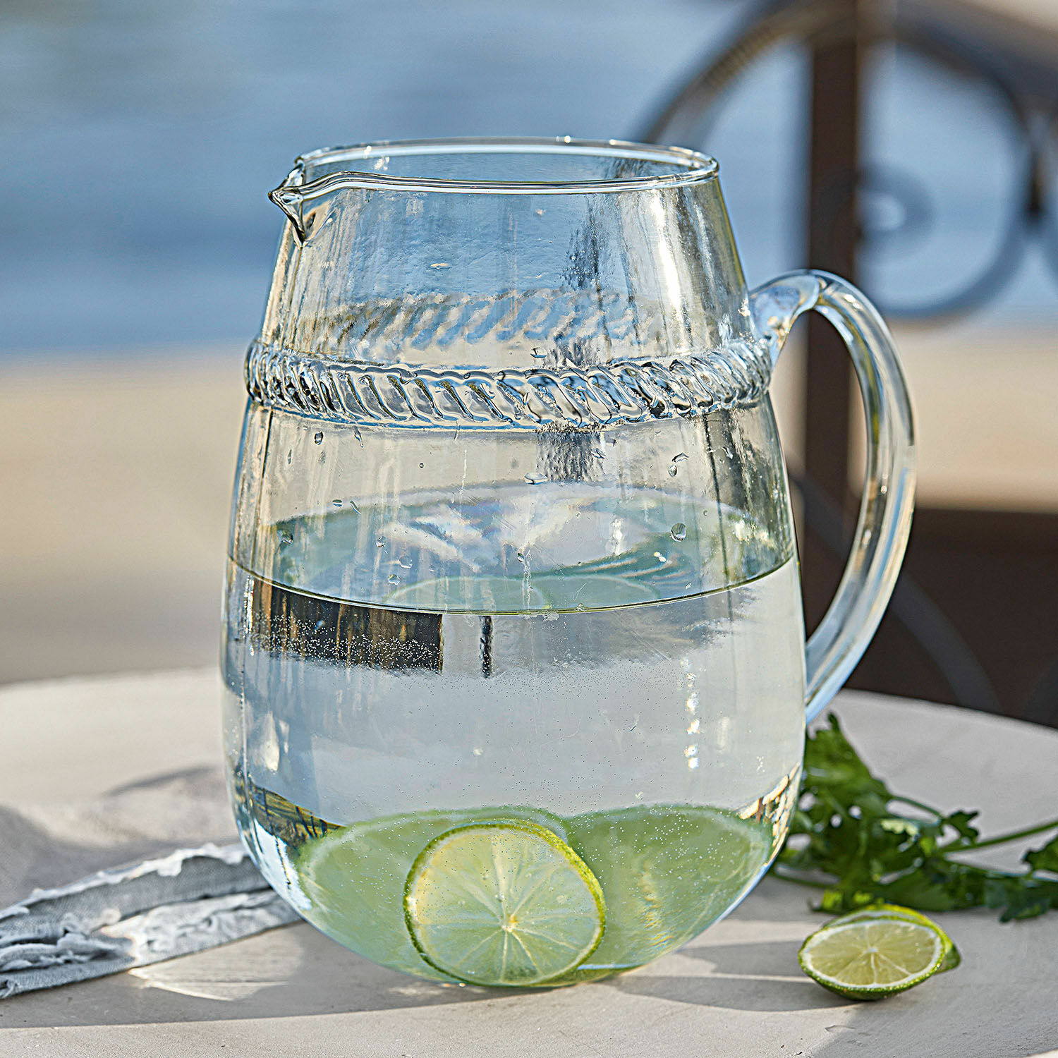 Kan Beiras Glazen karaf van helder glas met water en limoenplakjes op tuintafel