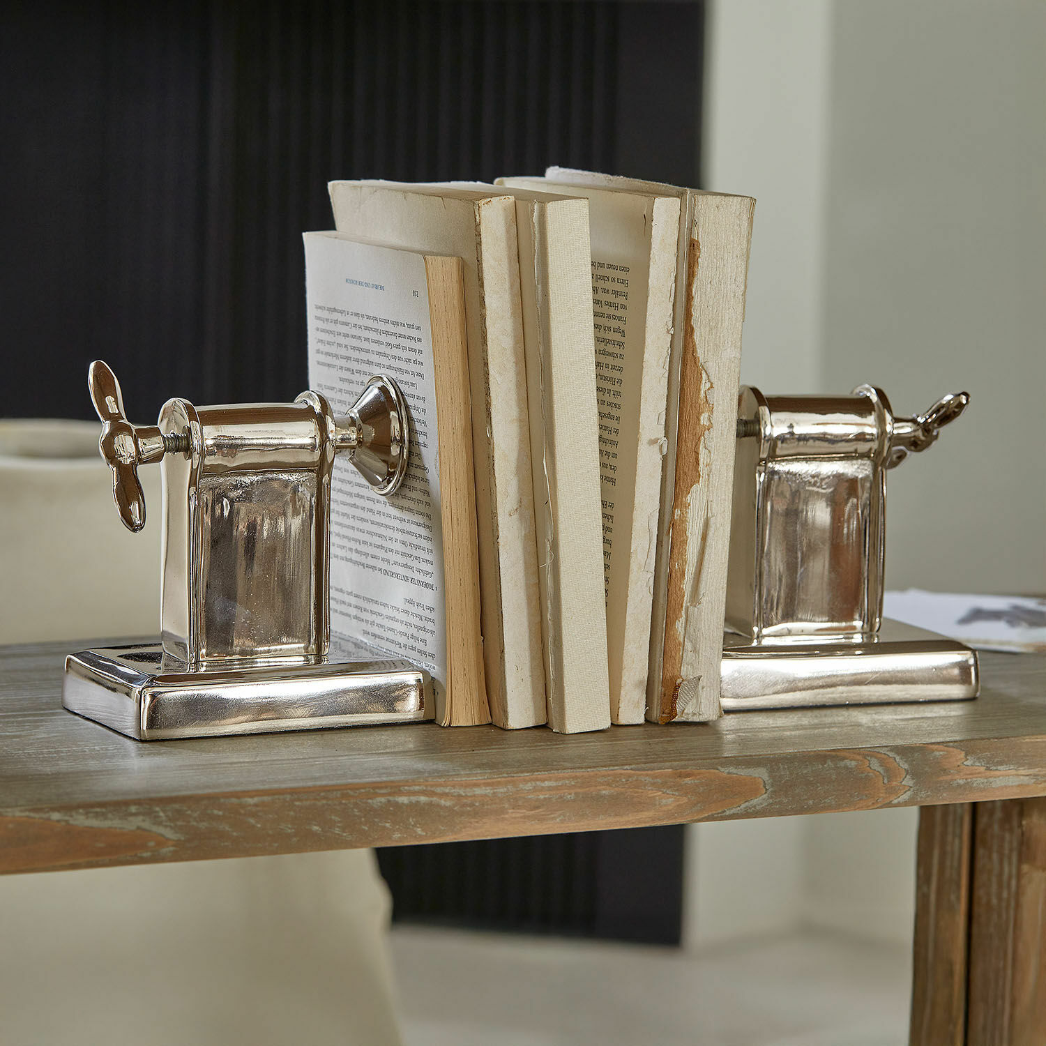 Boekensteun set van 2 Iskora Zilverkleurige metalen boekensteunen in schroefvorm op houten tafel, woondecoratie