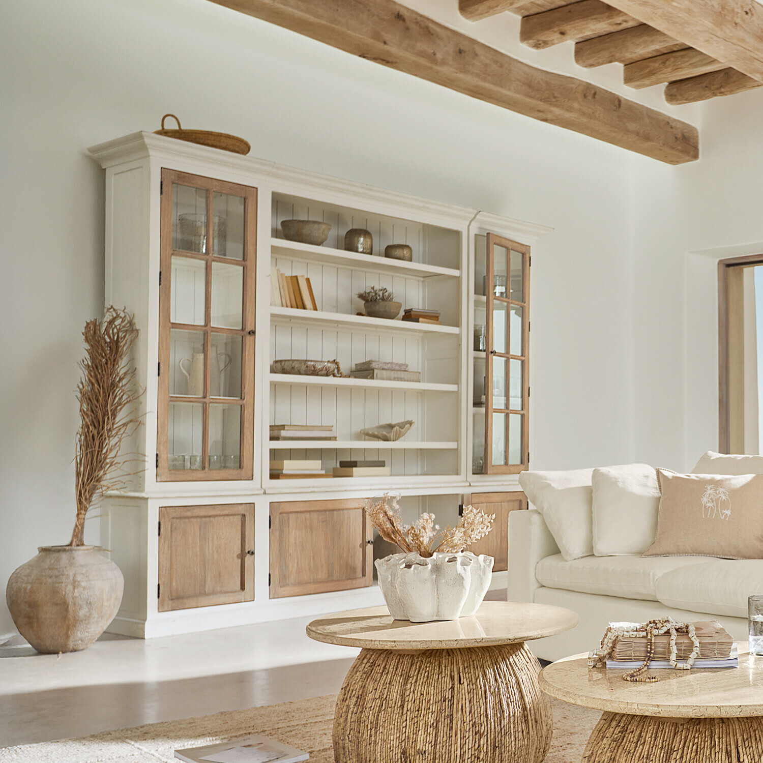 Kast Springford Lichte houten kast met glazen deuren en natuurlijke decoraties in een lichte woonkamer