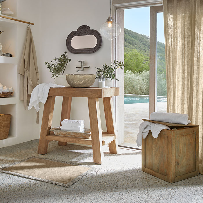 Badkamer met houten wastafelmeubel en stenen kom, natuurlijke kleuren en planten