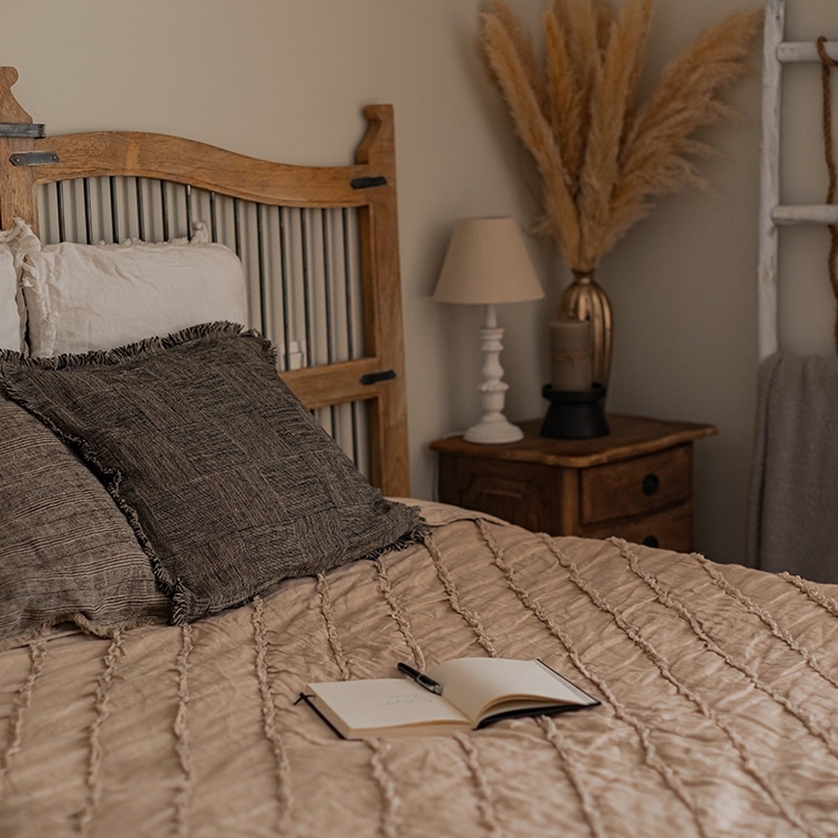 Gezellige slaapkamer met houten bed en beige dekbed, natuurlijke boho decoratie