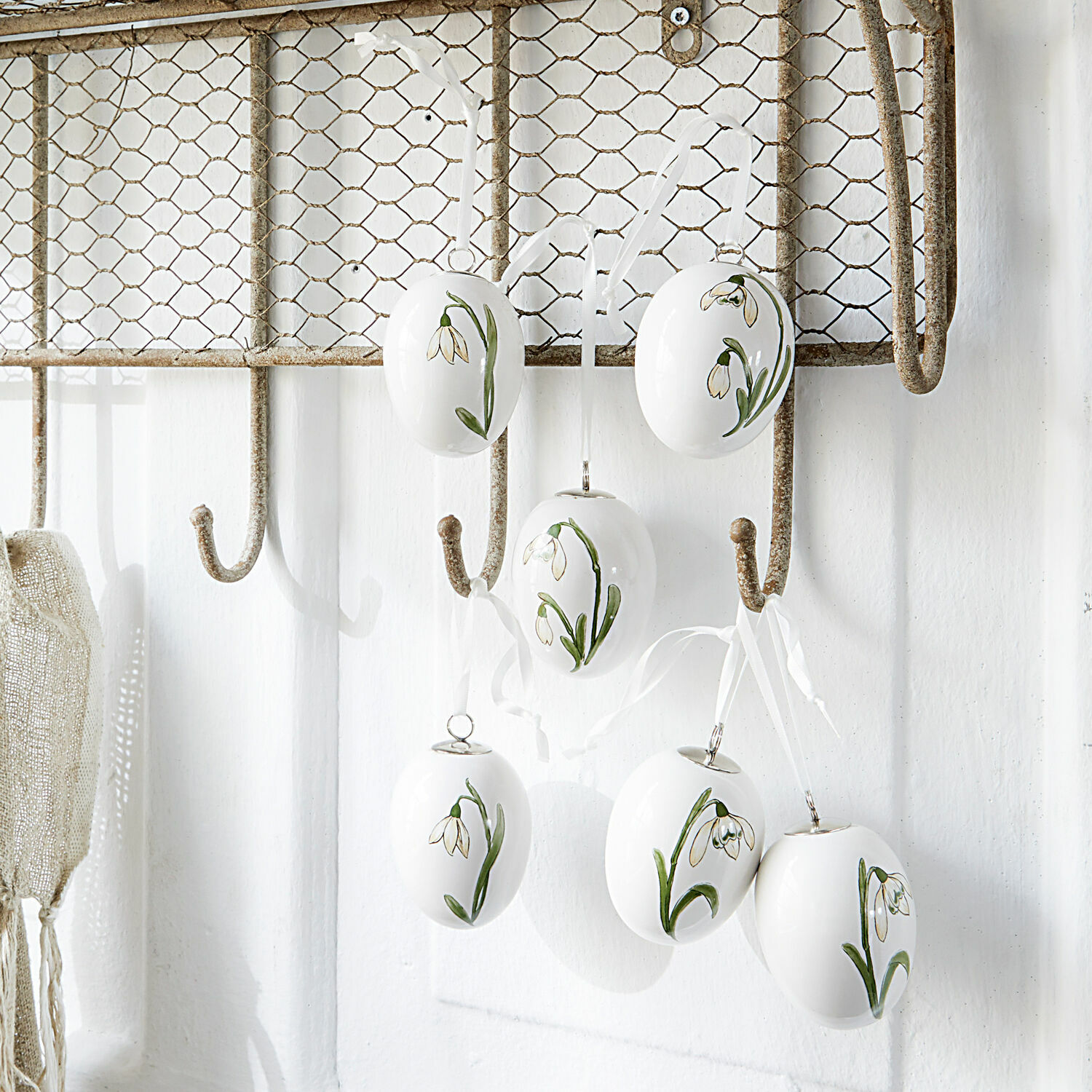 Paasei set van 6 Willmare Witte keramische eieren met groene bloemen hangend aan metalen haak, lentedeocratie