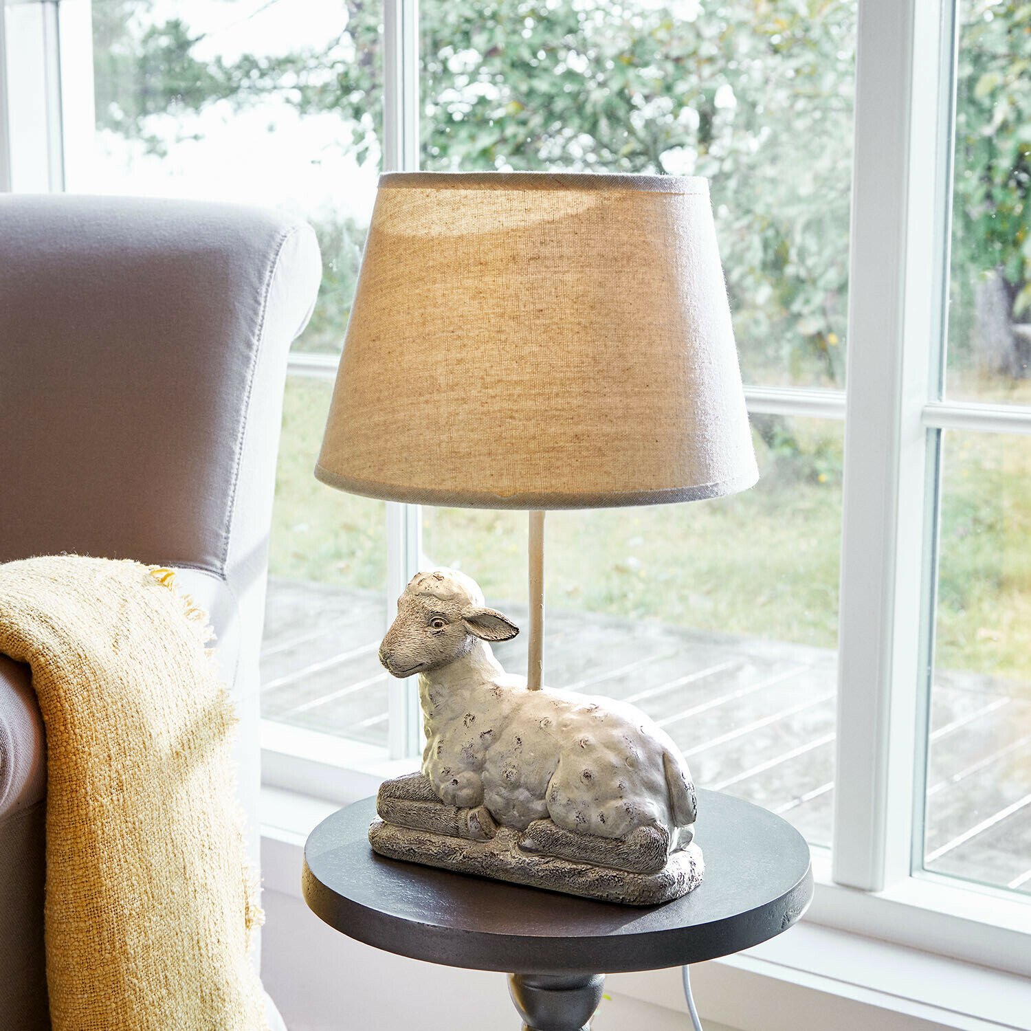 Tafellamp met beige kap en voet in de vorm van een schaap van decoratief steenmateriaal