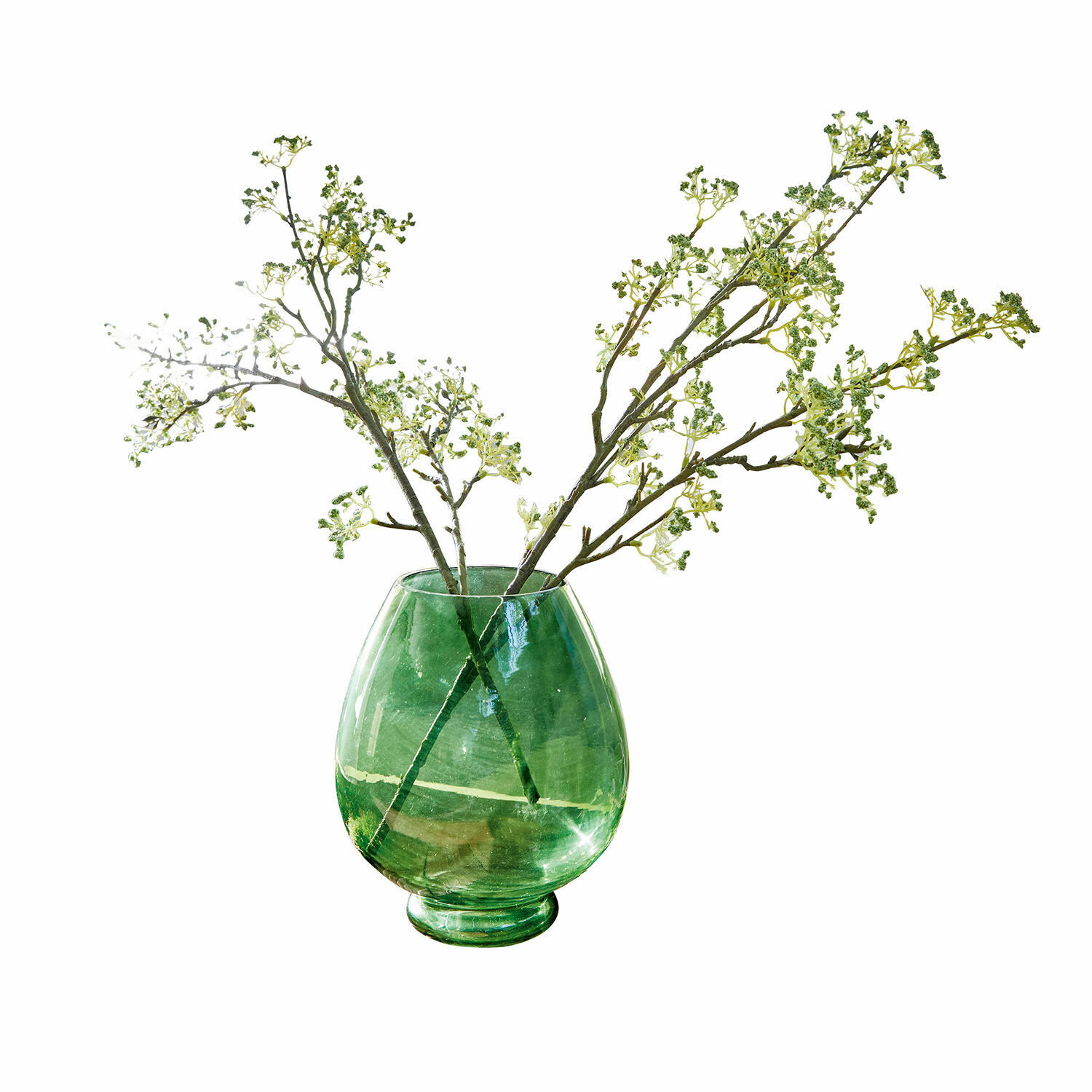 Groene glazen vaas met decoratieve takken op witte achtergrond, woondecoratie