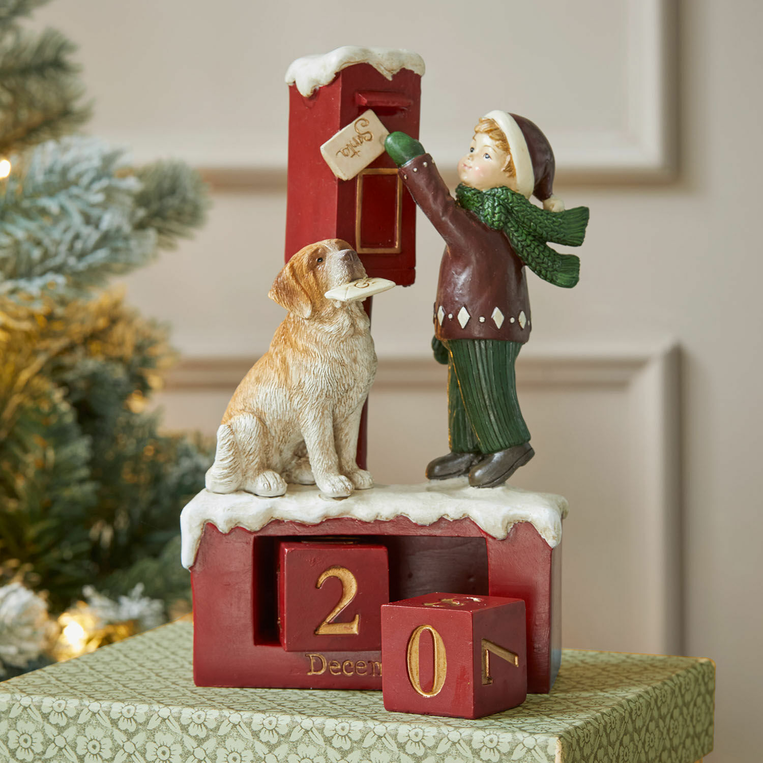 Kalender Norrholm Rode adventskalender met figuren van kind en hond op besneeuwde basis, kerstdecoratie