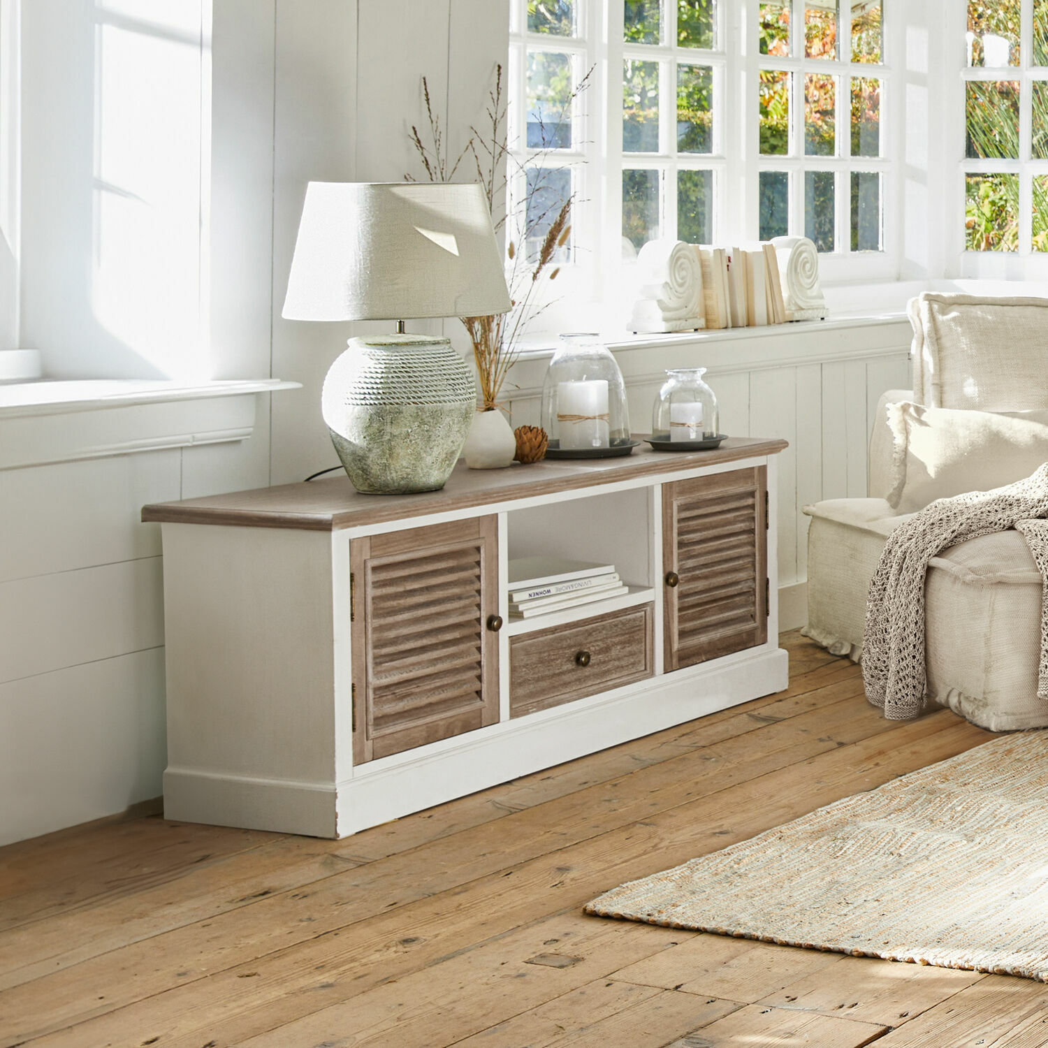 Sideboard Glencoe Rustieke houten kast met wit frame en bruine deuren, lamp en decoratie op het blad in lichte kamer
