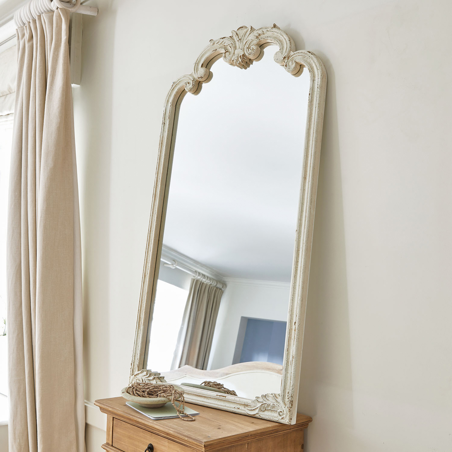 Staande spiegel met witte, verouderde houten lijst en decoratief patroon voor interieur