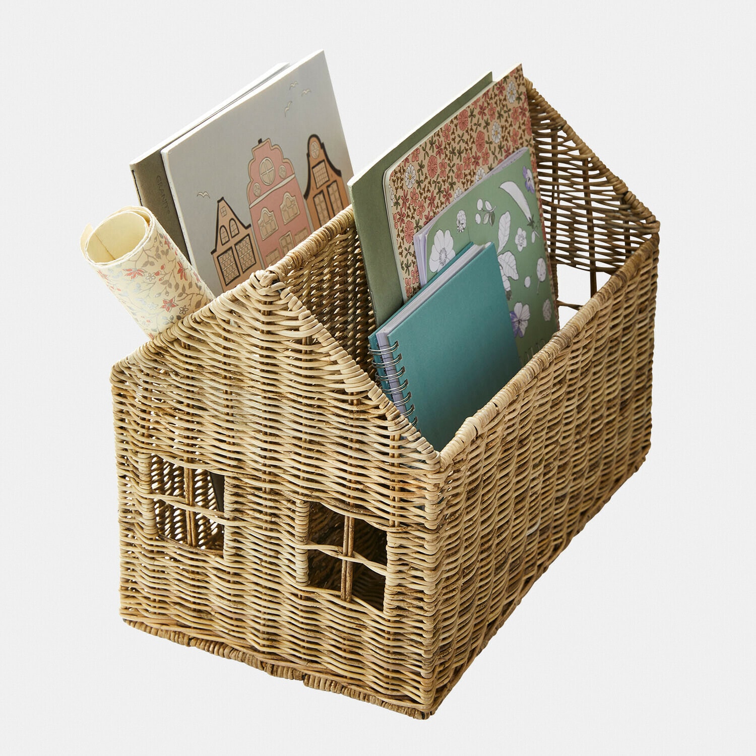 Rieten mand in huisvorm met vakken voor boeken en notitieboekjes in pasteltinten