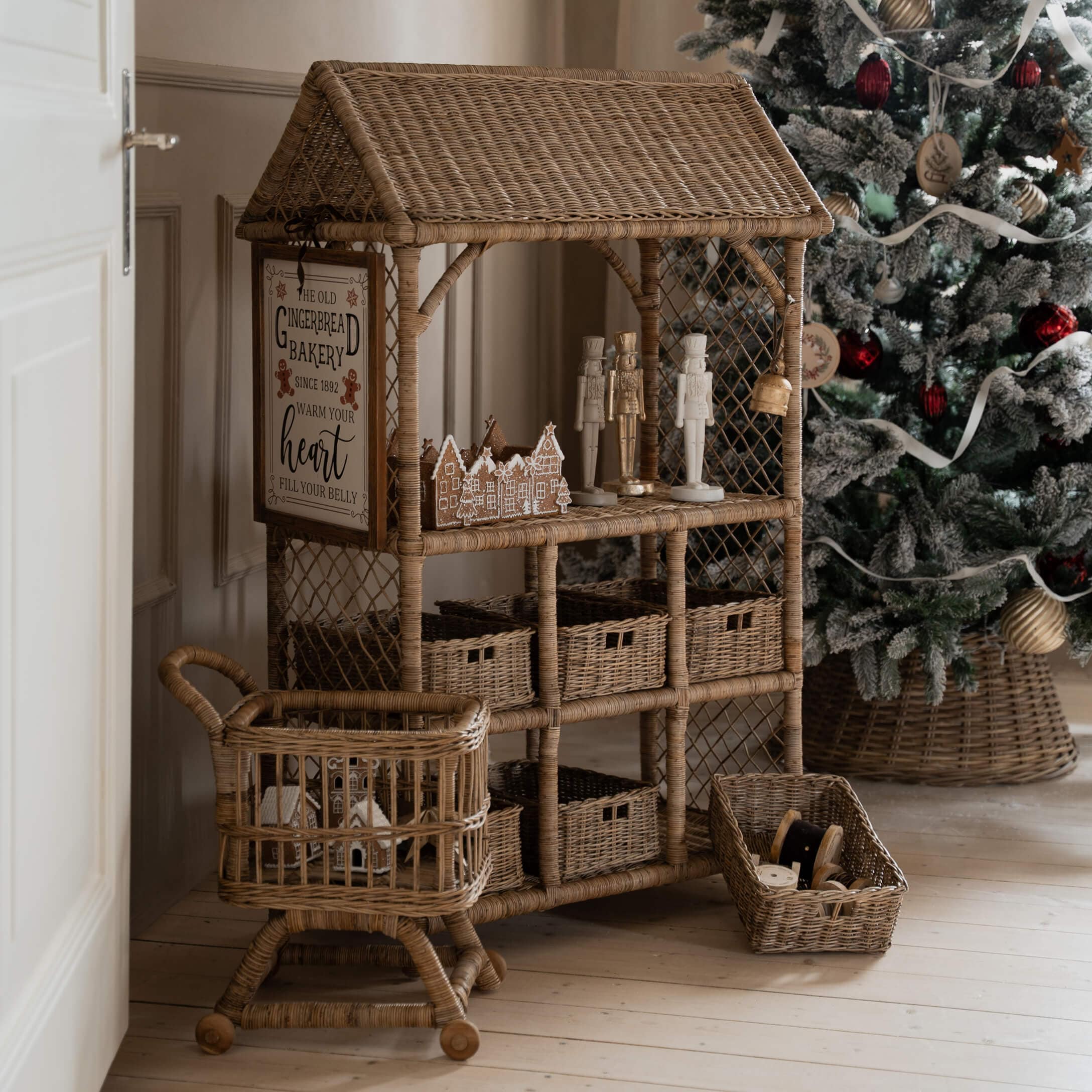 Natuurlijke rotan meubel met kerstdecoraties en versierde kerstboom op de achtergrond