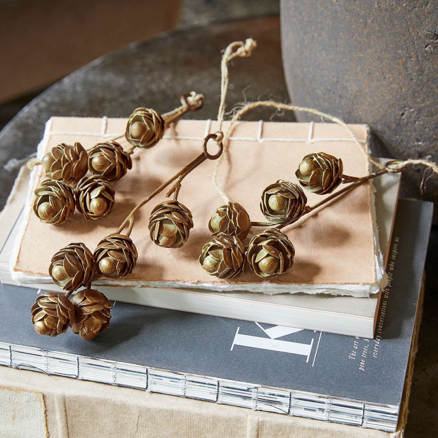 Hanger set van 3 Lazimra Decoratieve takken met bruine dennenappels op een stapel boeken, natuurlijke interieurdecoratie