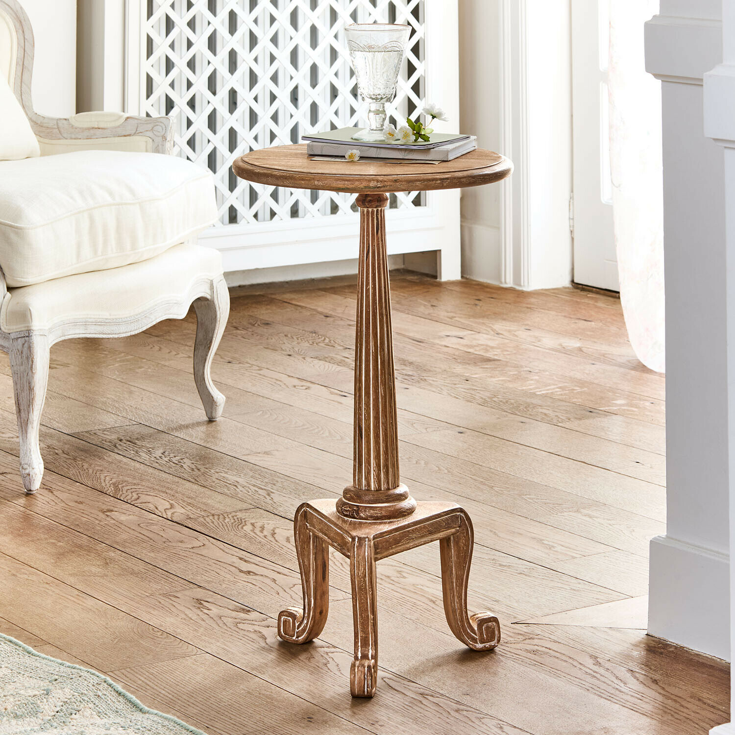 Ronde houten bijzettafel in natuurlijke kleur met sierlijke poten in vintage stijl in lichte kamer