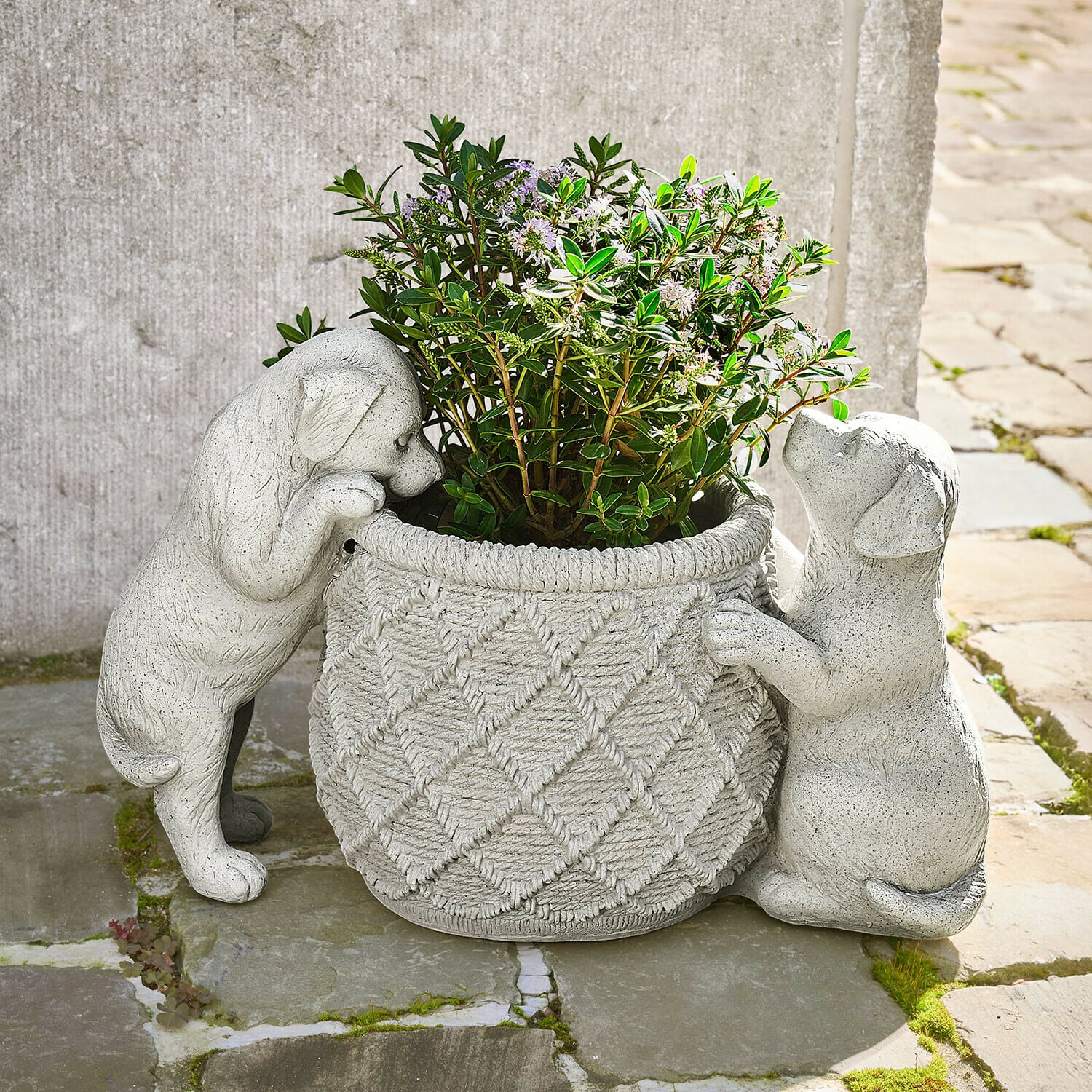 Sierpot Marnja Grijze stenen bloempot met twee puppyfiguren die een plant met groene bladeren vasthouden