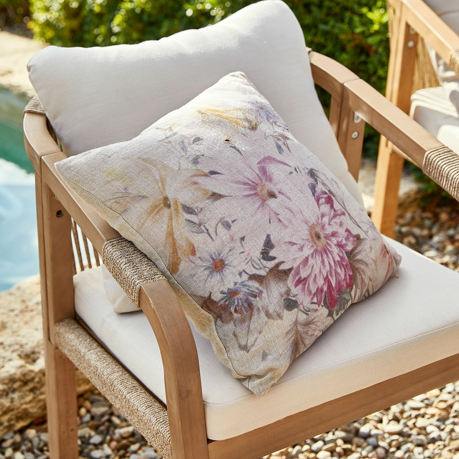 Kussenhoes Evie Decoratief kussen van beige linnen met bloemenprint op een houten tuinstoel