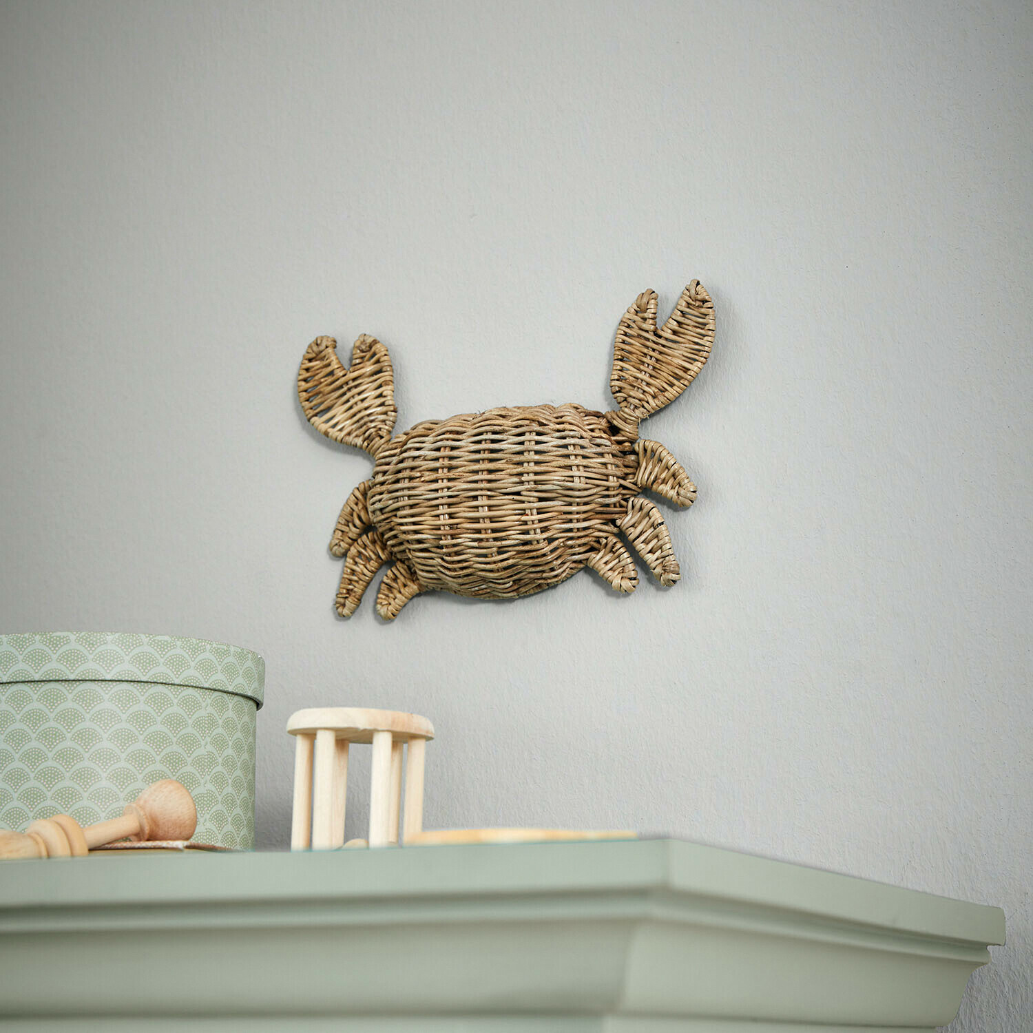 Wanddecoratie krab van natuurlijk riet in lichte kamer, maritieme woonaccessoire