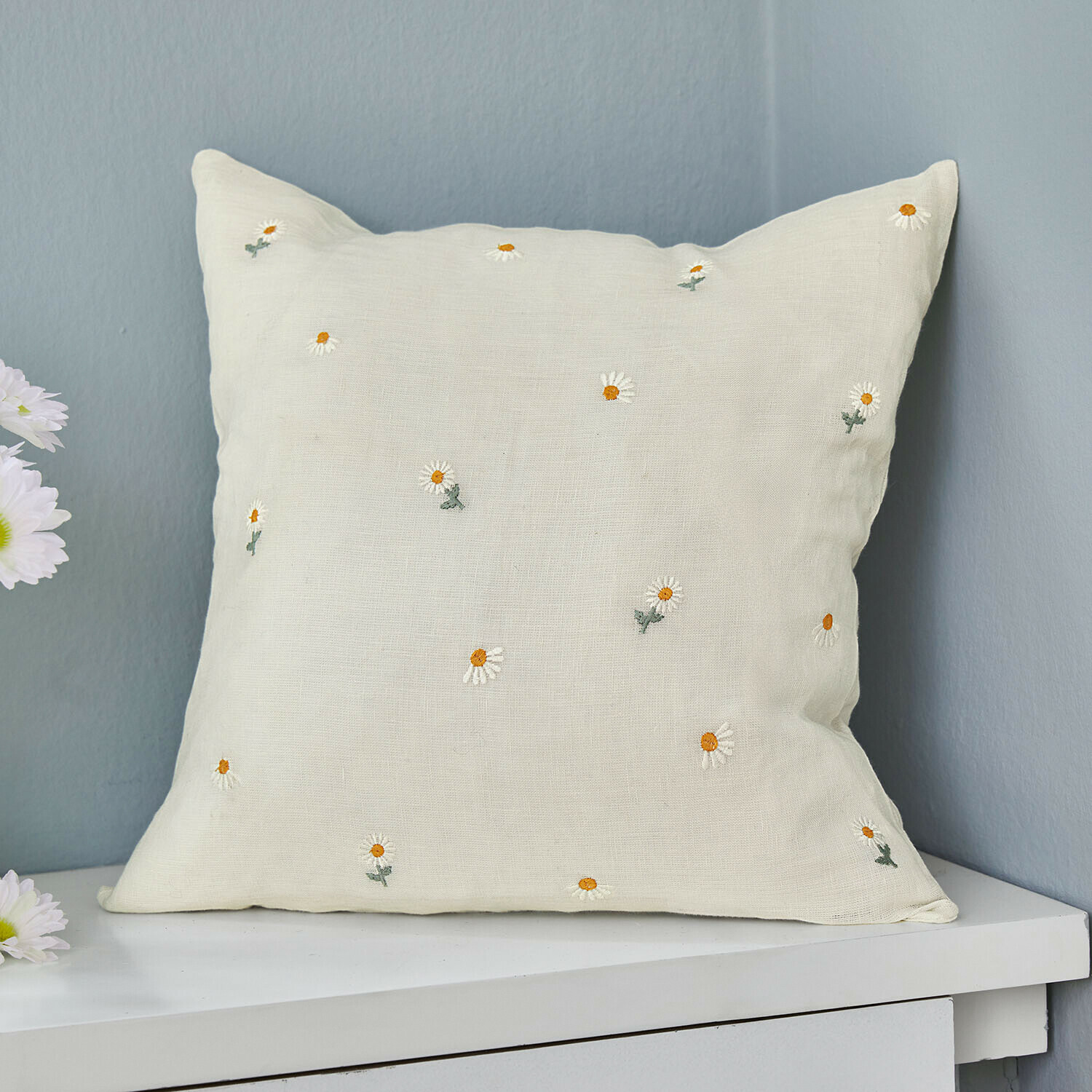 Beige linnen kussen met geborduurde witte en gele madeliefjes, woondecoratie