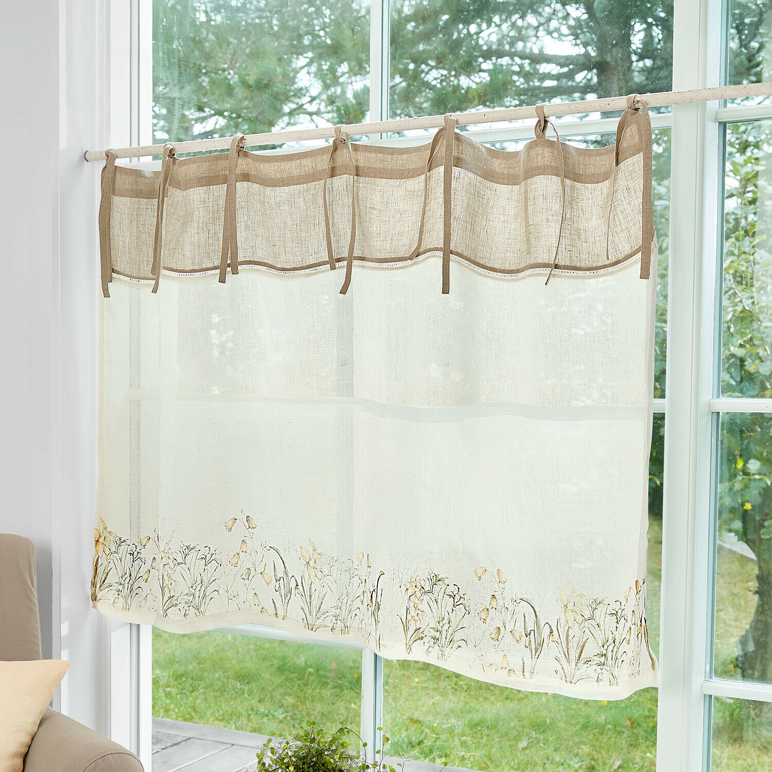 Beige linnen gordijn met bloemmotief en bindlinten bovenaan voor een gezellige woonkamer