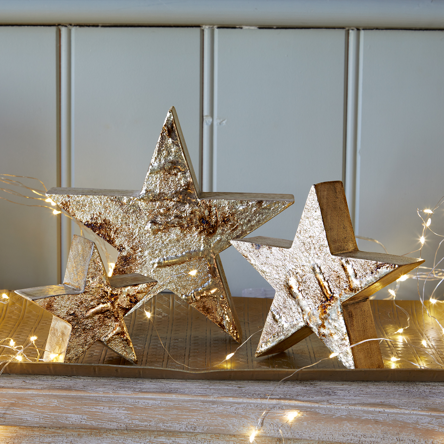 Set van drie decoratieve sterren van gestructureerd goudkleurig metaal voor feestelijke interieurdecoratie