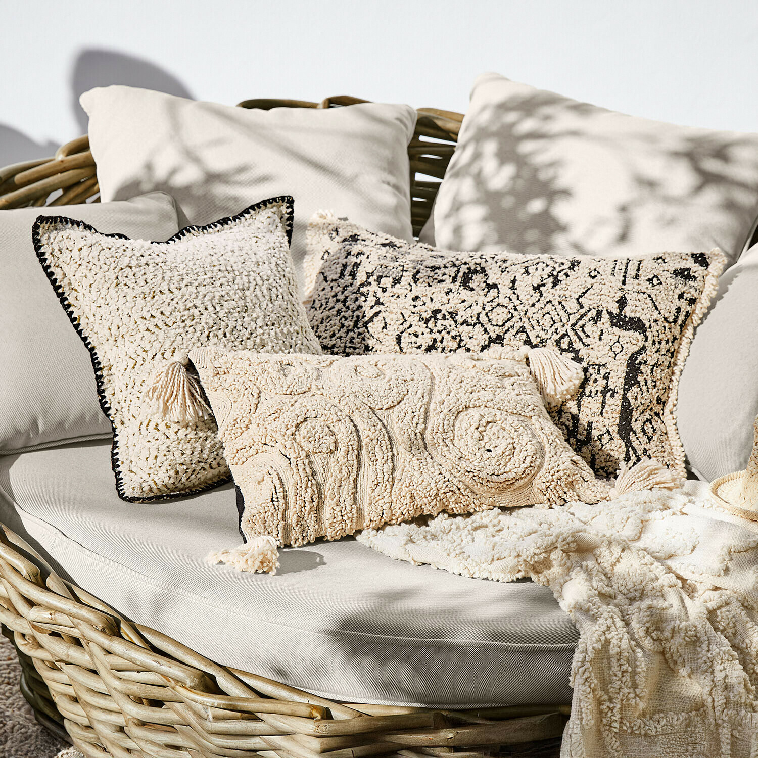 Kussenhoes set van 3 Norlinn Set crème decoratieve kussens van zacht materiaal op rotan bank, boho stijl