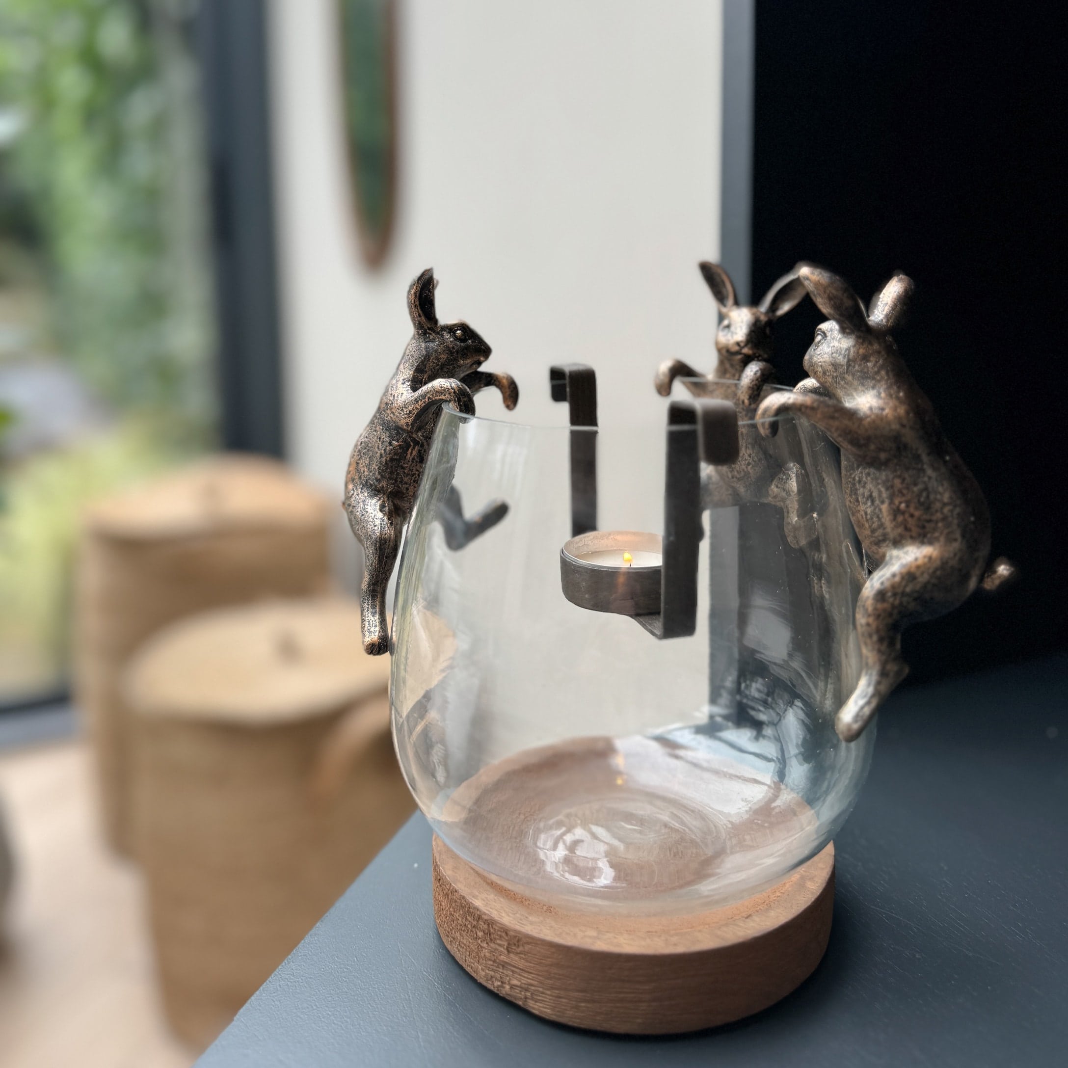 Glazen theelichthouder met houten voet en messingkleurige metalen konijnen, woondecoratie