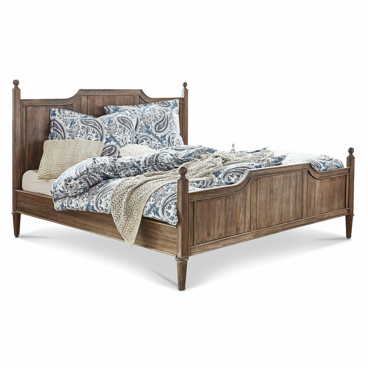Bruin houten bed met blauw patroon beddengoed en beige gebreide deken voor sfeervolle slaapkamer
