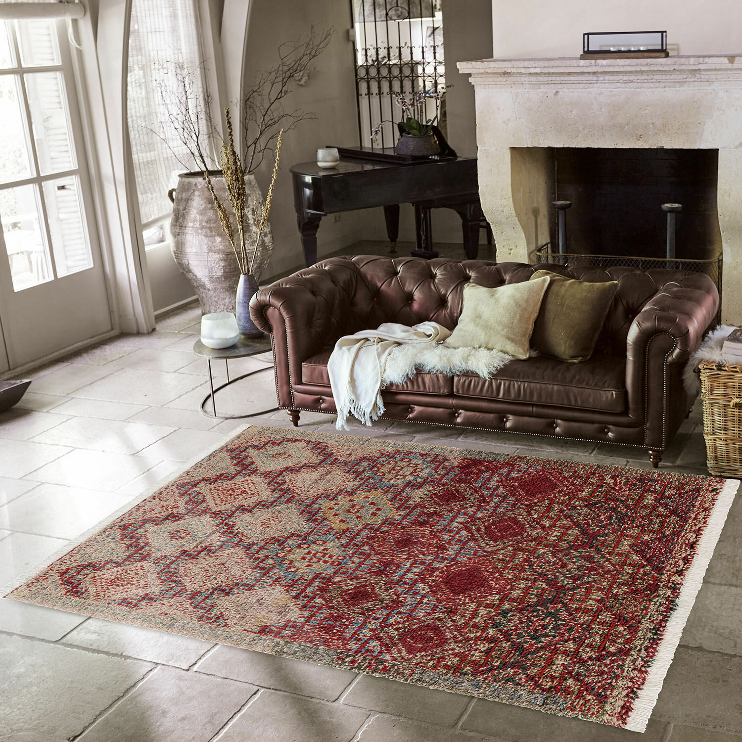 Rood-beige patroon vloerkleed op stenen vloer bij bruine leren bank in woonkamer