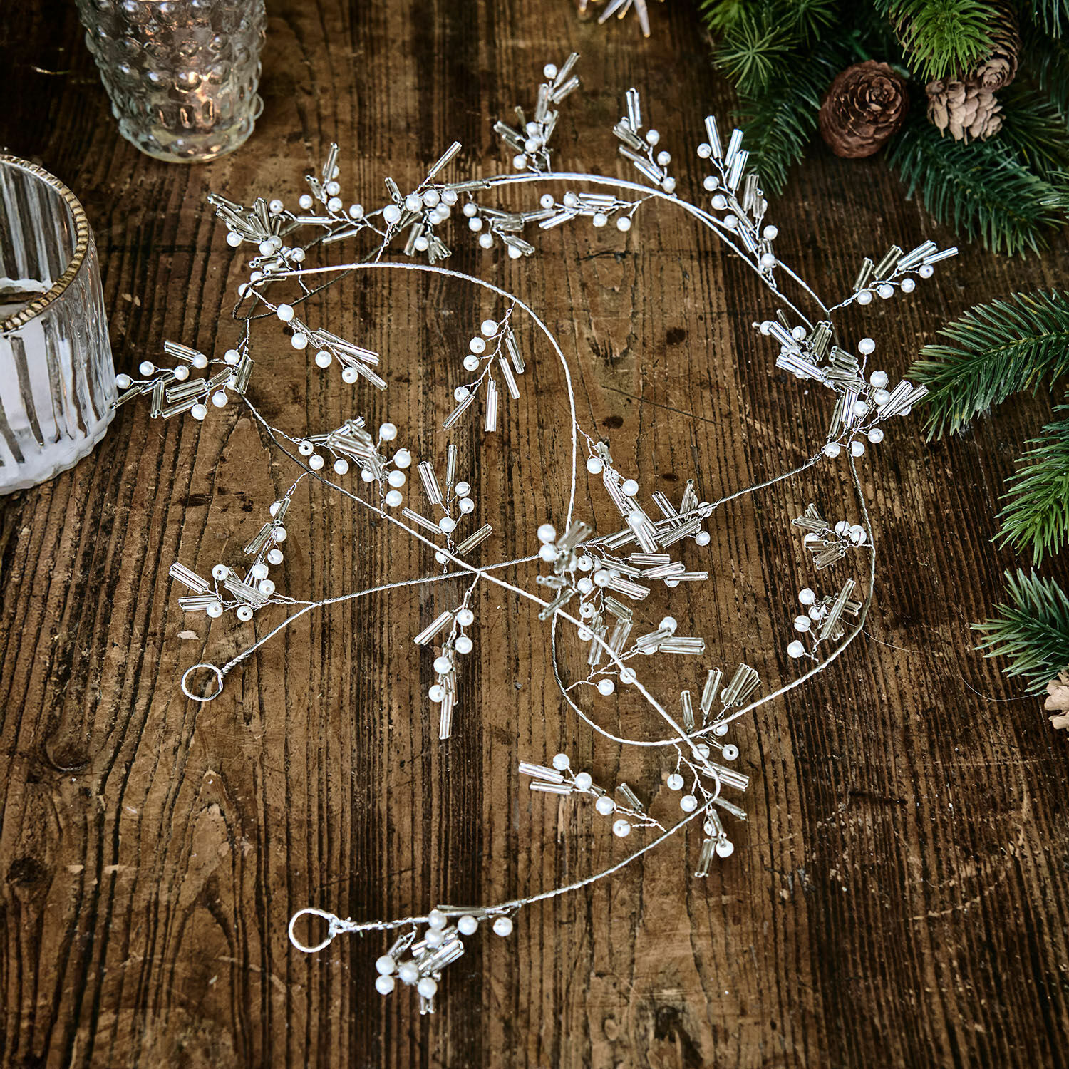 Guirlande Hybern Fijne zilveren decoratieve ketting met witte parels op houten tafel, feestelijke kerstversiering