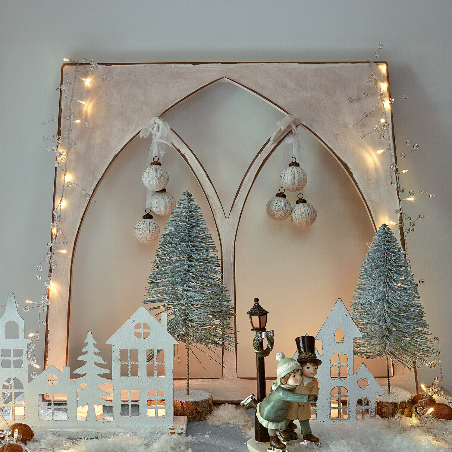 Siervenster Kiraline Kerstdecoratie met witte huisjes, groene bomen en schaatsersfiguren op kunstsneeuw