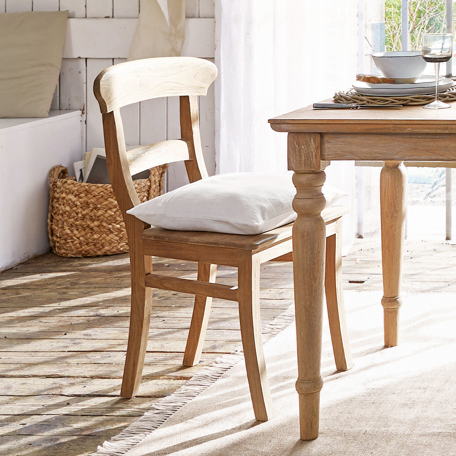 Houten stoel in natuurlijke kleur met wit kussen in lichte, rustieke kamer