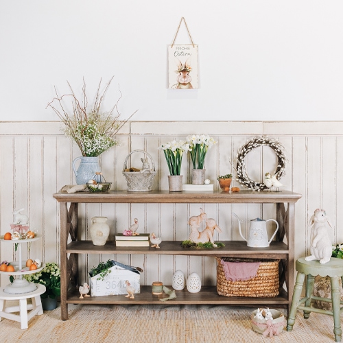 Houten kast met paasdecoraties, bloemen en rieten mand in lichte kamer