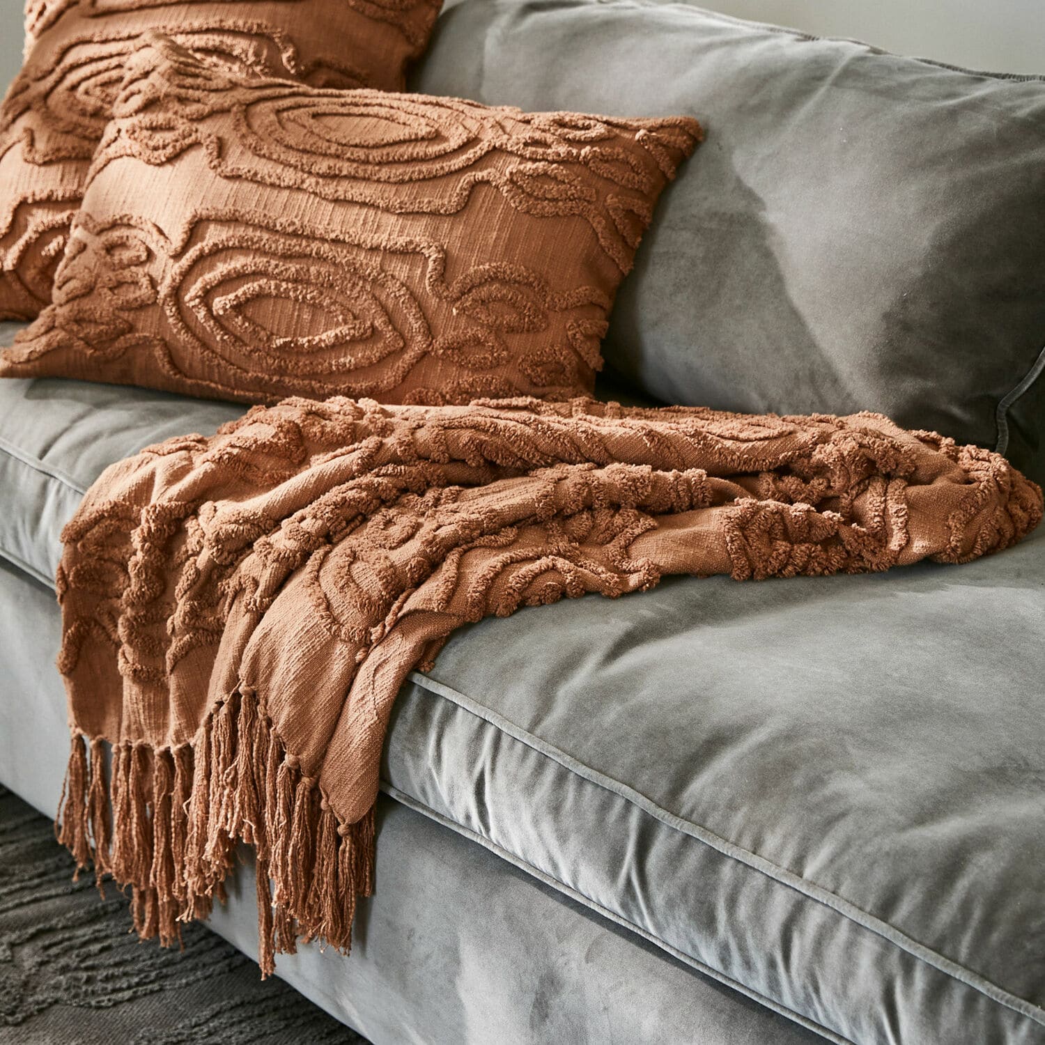 Plaid Boclour Bruine decoratieve deken en kussen met textuur op grijze fluwelen bank in woonkamer