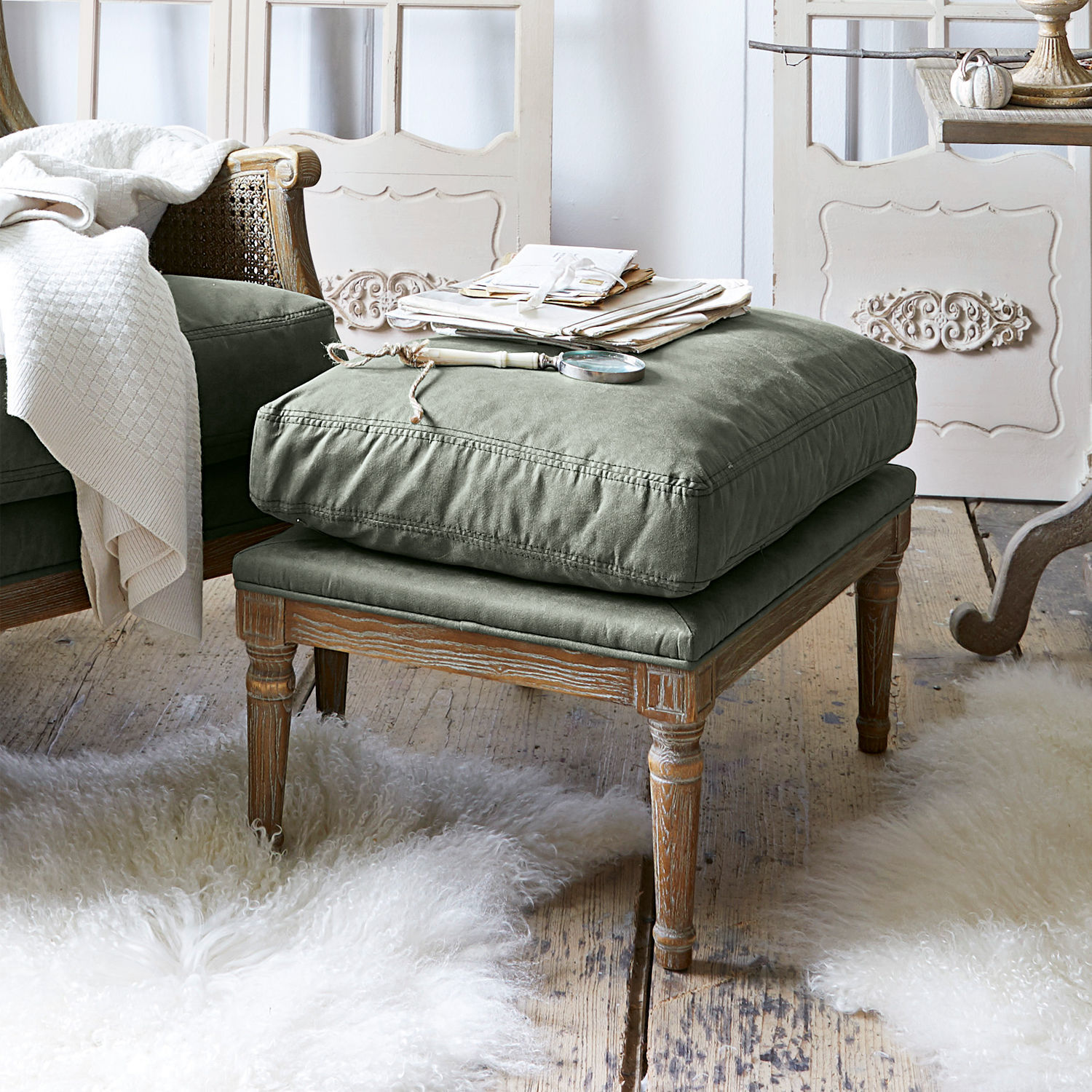 Hocker Greenbrier Voetenbank met houten frame en groene stoffen zitting in een gezellige vintage interieur