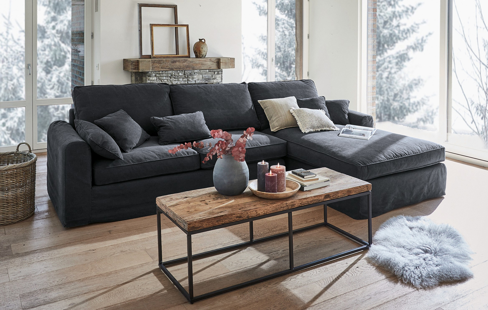 Grijze stoffen hoekbank in industriële stijl met houten salontafel en decoratie in lichte woonkamer