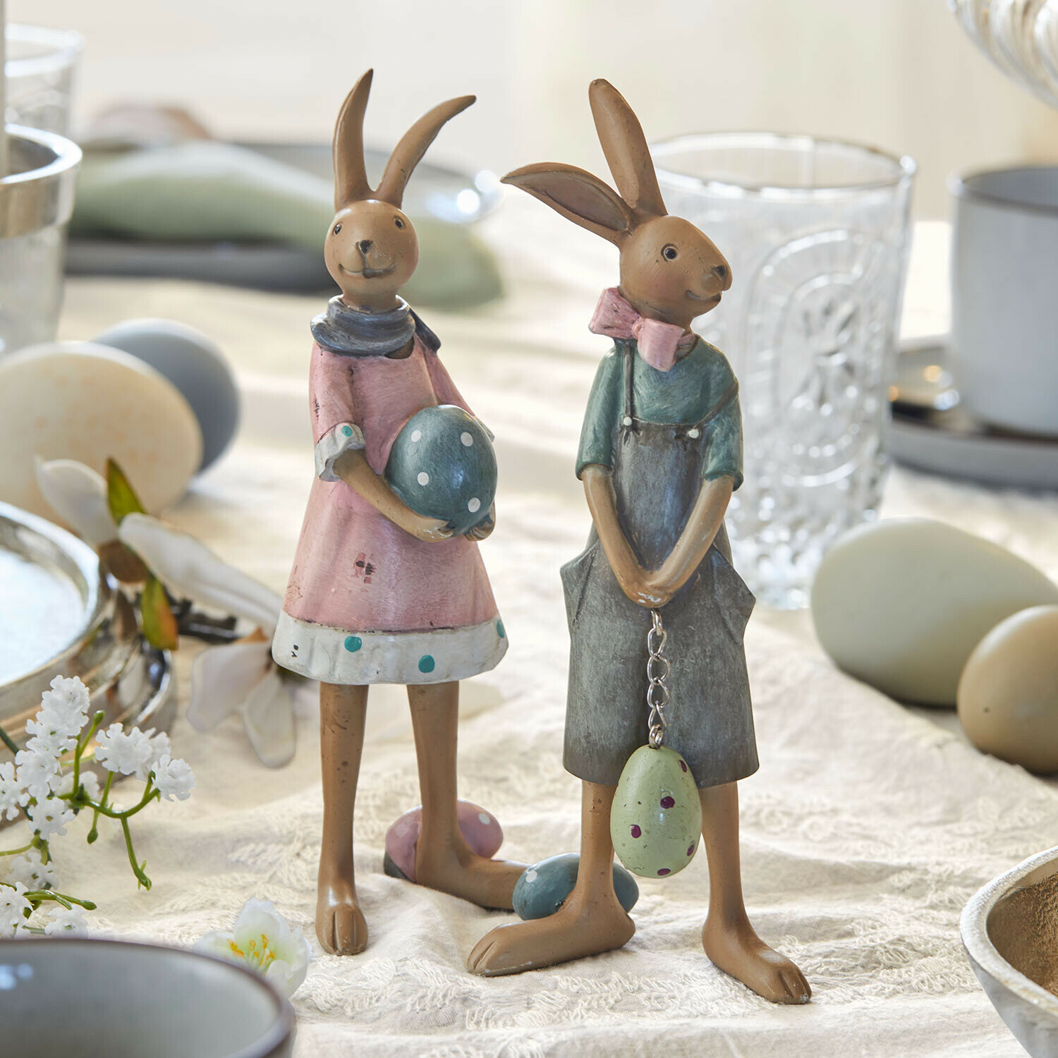 Haasje set van 2 Sivalex Twee decoratieve metalen konijnenfiguren in pasteltinten met paaseieren op een tafel