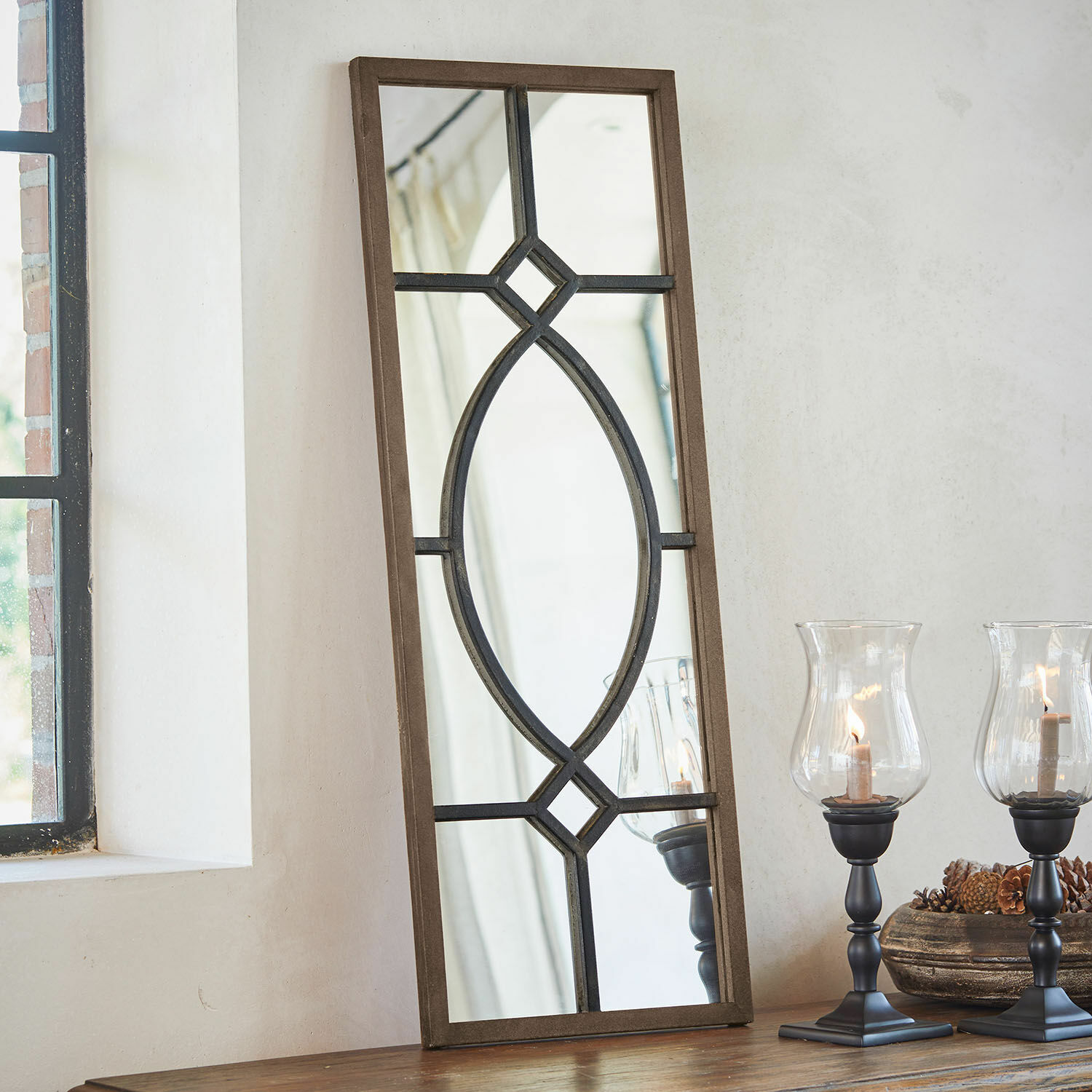 Spiegel Millery Rechthoekige spiegel met bruine houten lijst en zwart metalen patroon op tafel met lantaarns