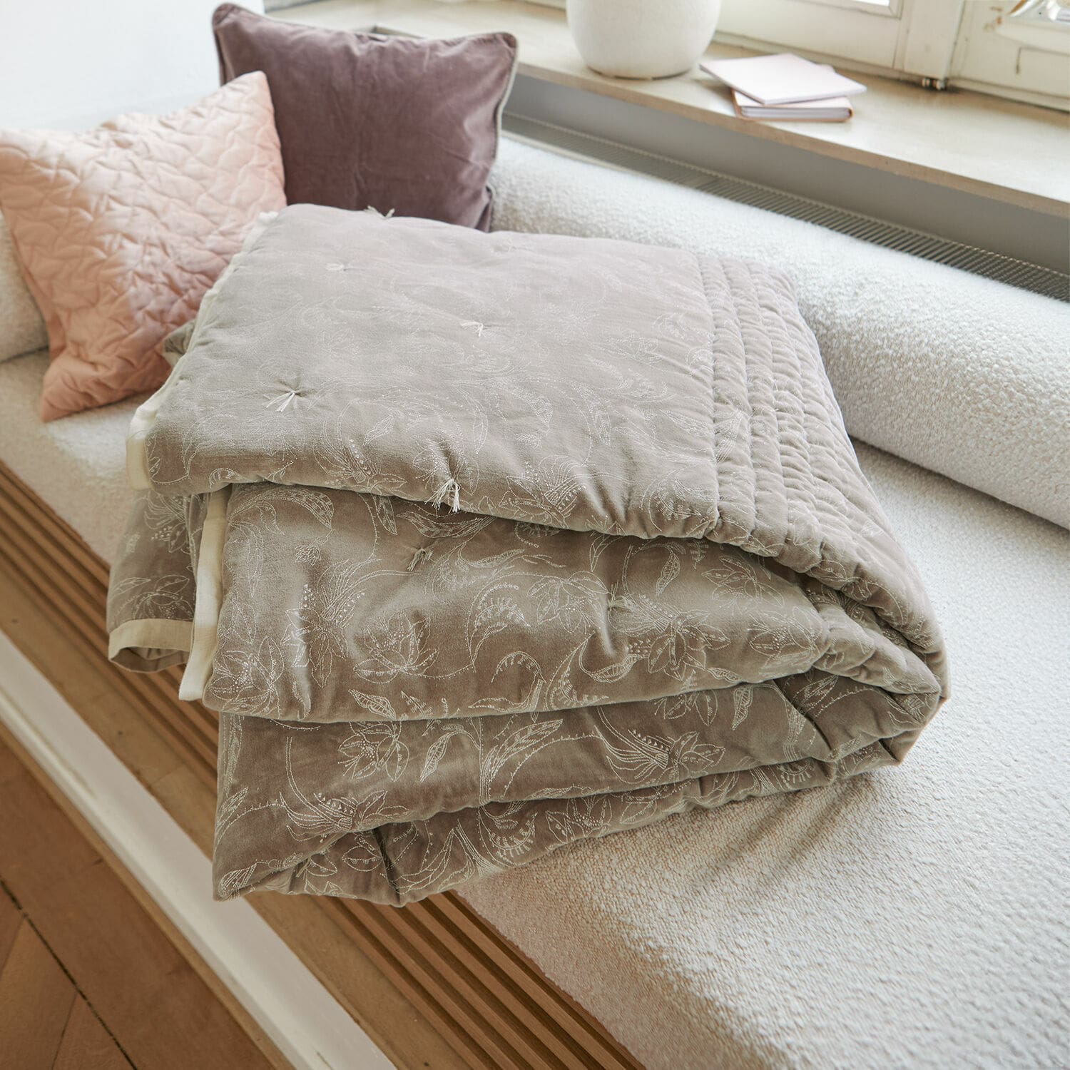 Quilt Olicianne Beige gewatteerde plaid met fijn bloemenpatroon op lichte bank in woonkamer