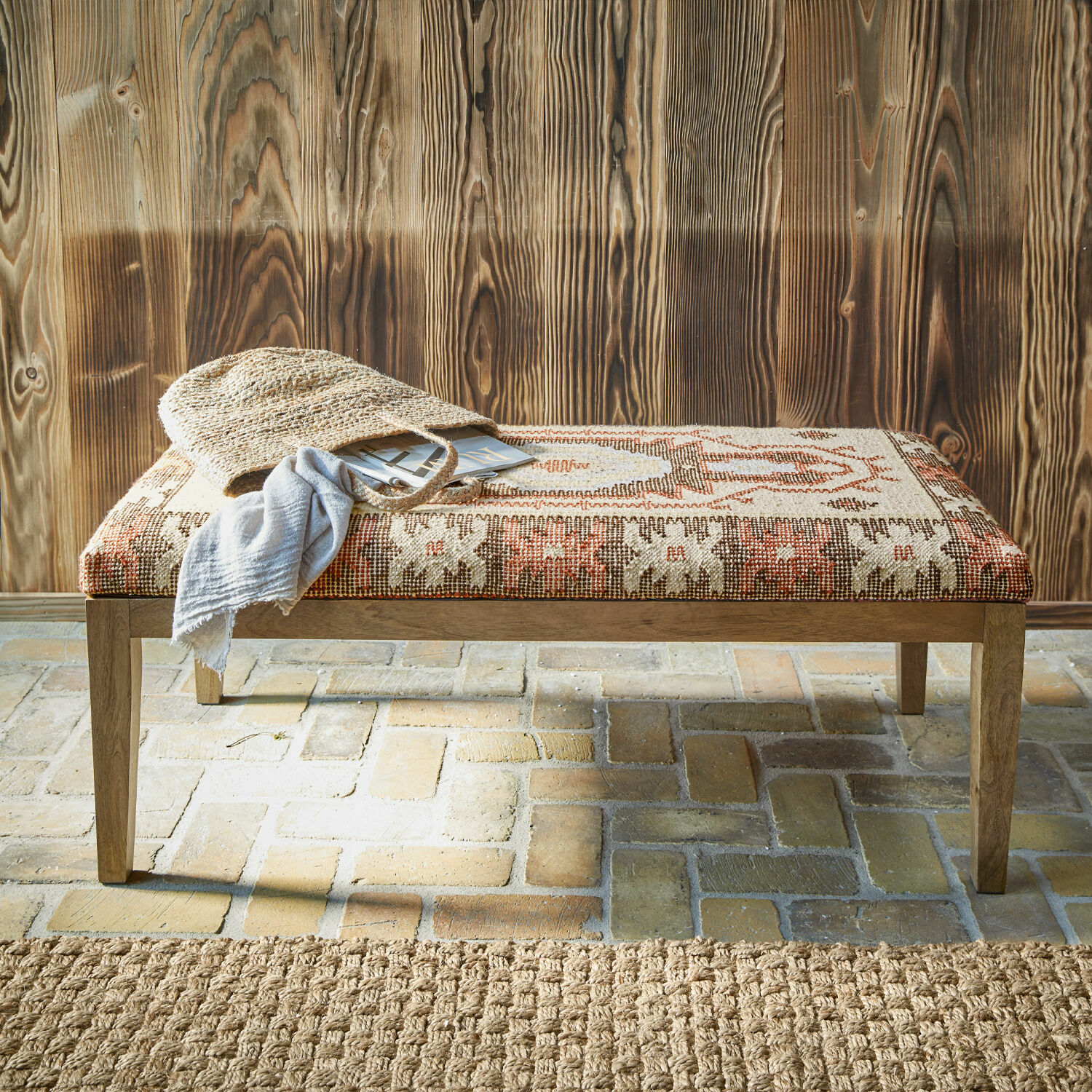 Bank met houten frame en bekleding met geometrisch patroon in warme beige en rode tinten