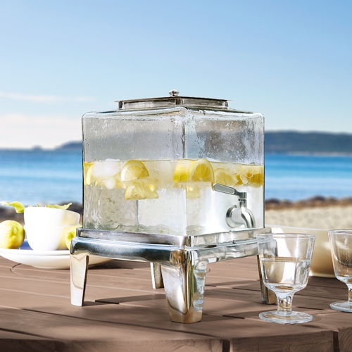 Glazen drankdispenser met metalen standaard, gevuld met citroenwater, perfect voor zomerse feesten