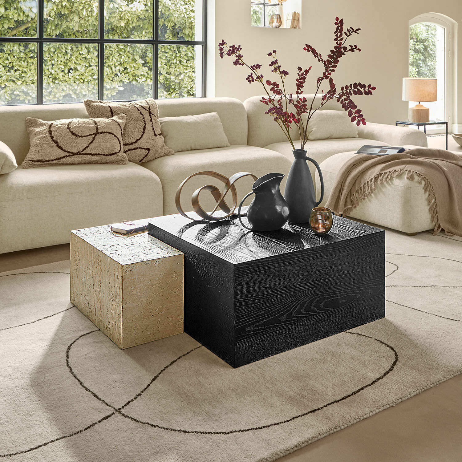 Salontafel Caleneuve Moderne woonkamer met beige bank en twee salontafels van hout en steen, decoraties op tafel
