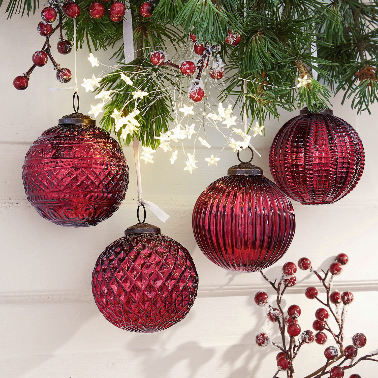 Kerstversiering set van 4 Ringas Rode glazen kerstballen met verschillende structuren en stervormige lichtjes aan groene takken